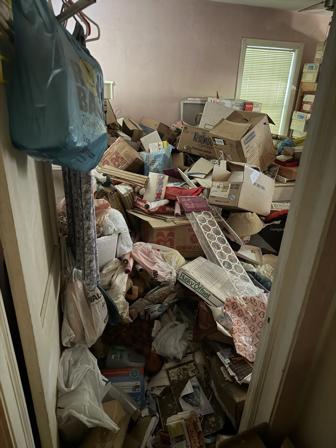 Boxes, bags and household belongings filling a room