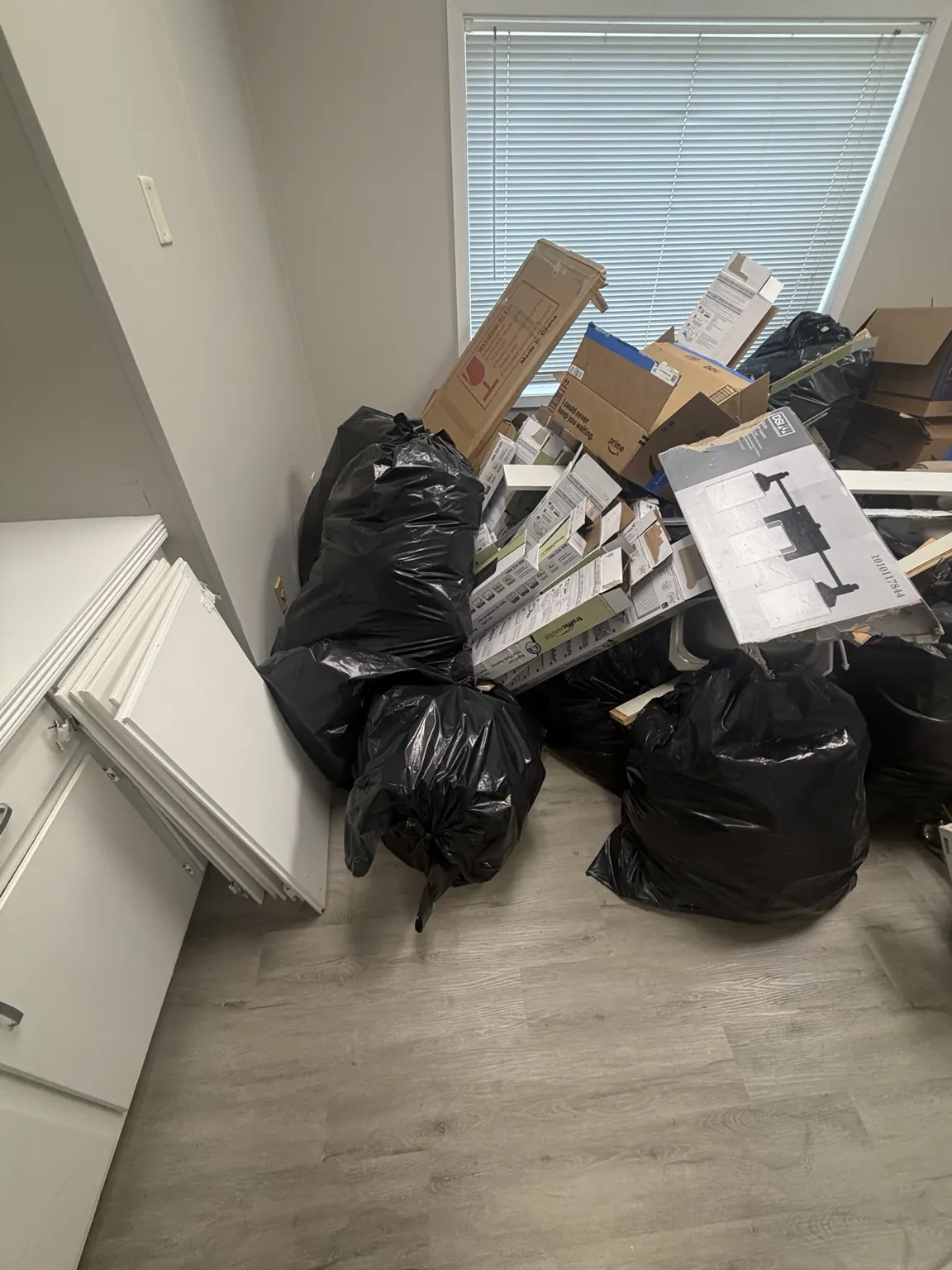 Black bags, cardboard boxes and loose material staged inside a Frisco office before cleanout