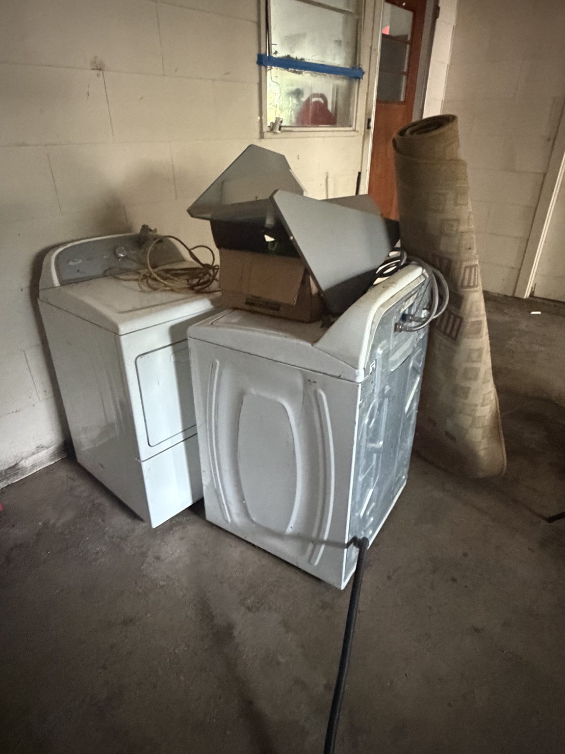 Washer and dryer inside a garage before removal