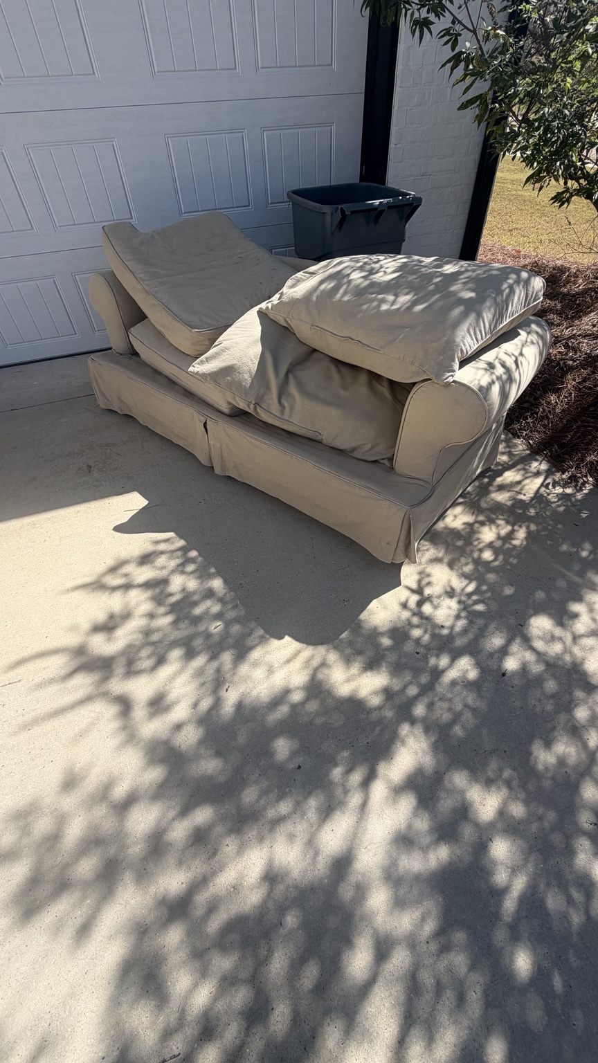 Large upholstered couch outside a home for same-day removal