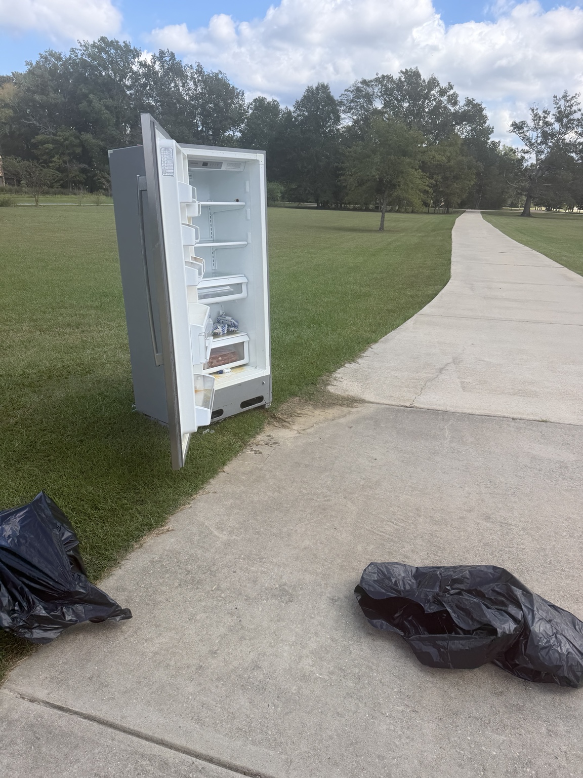 Unwanted refrigerator staged outdoors for pickup